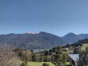 a view of a mountain range with a house and a lake at Cabaña Bellavista in Cochamó