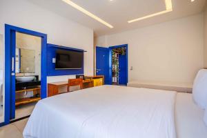 a bedroom with a large white bed and a television at Vila Gallina Pousada in Jericoacoara +29 photos
