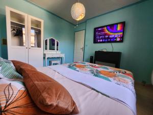 a bedroom with a bed and a tv on the wall at Le Ciel Bleu in Arles