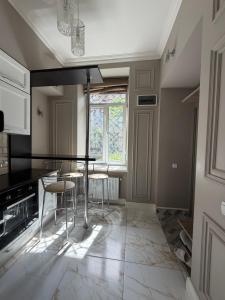 a kitchen with a table and chairs and a window at Historical space in Lviv +5 photos