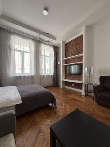 a bedroom with a bed and a couch and a tv at Historical space in Lviv