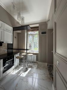 a kitchen with a table and chairs and a window at Historical space in Lviv