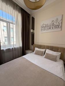 a bedroom with a large white bed with a window at Historical space in Lviv