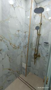 a marble shower with two lights in a bathroom at Osh apartment in Osh