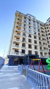 a large apartment building with a playground in front of it at Osh apartment in Osh