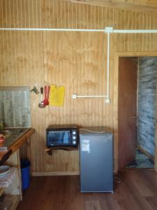 a kitchen with a small refrigerator and a microwave at Cabaña Bellavista in Cochamó