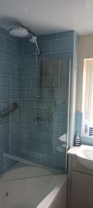 a bathroom with a shower with blue tiles at Comfortable Double Bedroom in Darlington +11 photos