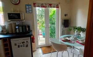 a kitchen with a table and a refrigerator and a door at Comfortable Double Bedroom in Darlington