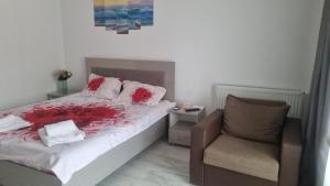 a bedroom with a bed and a chair at Garsoniera Adriana in Mangalia