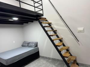 a room with a bed and a spiral staircase at Mini FLAT 02 Jataí Go in Jataí