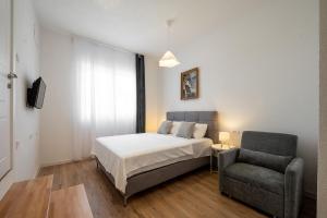 a bedroom with a bed and a chair at Harmony Point in Bar