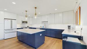 a large kitchen with blue cabinets and white appliances at Rehoboth Beach - 24 Brooklyn Ave Unit E in Rehoboth Beach