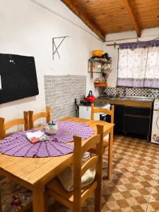 a kitchen with a wooden table with chairs and a tableablish at Alojamiento EYO en Chuy con Baño Privado y Aire Acondicionado in Chuy