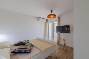 a small bedroom with a bed and a tv at Apartments Lučina in Bol