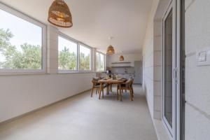 a kitchen and dining room with a table and windows at Apartments Lučina in Bol