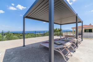 a group of tables under a pavilion on a patio at Apartments Lučina in Bol
