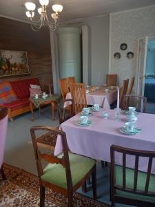 ein Esszimmer mit einem rosa Tisch und Stühlen in der Unterkunft Tyynelä in Juupajoki