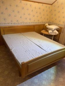 ein großes Bett in einem Zimmer mit einem Stuhl in der Unterkunft Tyynelä in Juupajoki