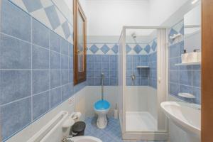 a blue tiled bathroom with a toilet and a sink at Camping Villaggio Egad in Favignana +119 photos