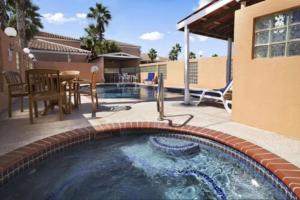 a swimming pool with a patio and a table and chairs at Super 8 by Wyndham South Padre Island in South Padre Island