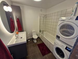 a bathroom with a washer and a washing machine at Top floor apartment with view in Reykjavík