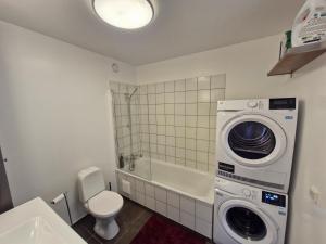 a bathroom with a washing machine and a toilet at Top floor apartment with view in Reykjavík +9 photos