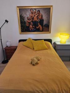 a stuffed teddy bear sitting on a bed with a painting at Top floor apartment with view in Reykjavík