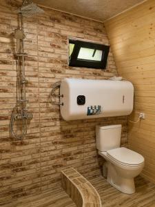 a small bathroom with a toilet and a window at Garden Cottages in Mestia +54 photos