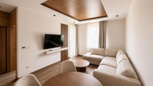 a living room with a couch and a tv at Hotel O2 Tornik in Ribnica