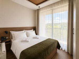 a bedroom with a large bed and a large window at Hotel O2 Tornik in Ribnica