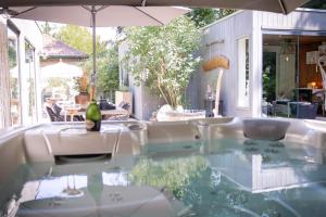 a table with chairs and an umbrella on a patio at AuxiliumWellness Get Back to Serenity in Grobbendonk