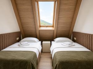 two beds in a small room with a window at Hotel O2 Tornik in Ribnica +24 photos