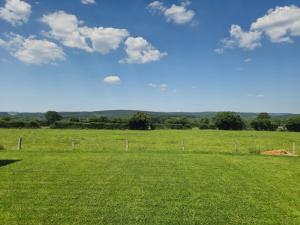 a field of green grass with a blue sky and clouds at Villa de l'Eau Rouge in Malmedy