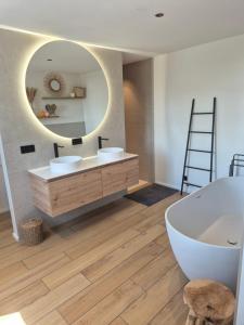 a bathroom with a tub and a large mirror at Villa de l'Eau Rouge in Malmedy