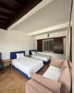 a hotel room with two beds and a couch at Blue Horizon in Cabo Negro