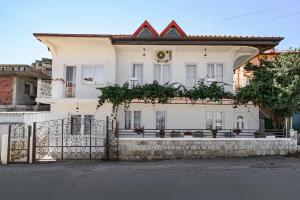a white house with a fence in front of it at Harmony Point in Bar