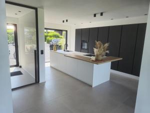 a kitchen with white countertops and black cabinets at Villa de l'Eau Rouge in Malmedy