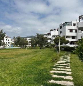 a walkway in a grassy field next to a building at Blue Horizon in Cabo Negro