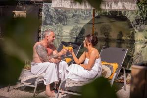 a man and a woman sitting at a table with a drink at AuxiliumWellness Get Back to Serenity in Grobbendonk