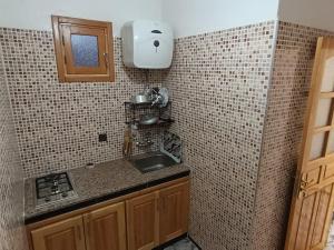 a kitchen with a sink and a tiled wall at Stay with dkouk in Akchour +47 photos