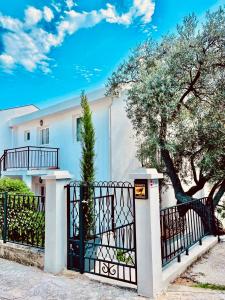 a white house with a gate and a tree at Villa Nemanja in Sveti Stefan