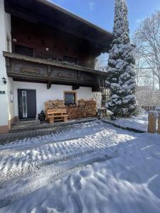 a house with a christmas tree in the snow at Haus am Bach in Erl