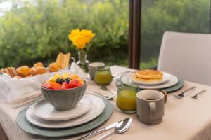 a table topped with a bowl of fruit and pancakes at Hotel Alto Monte Hacienda & Spa - Only Adults in Chiguirí Arriba