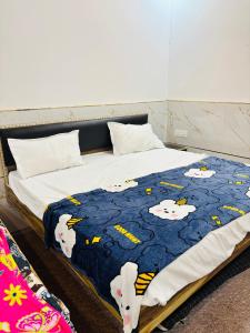 a bed with a blue blanket with cows on it at Maa chamunda dham in Mathura