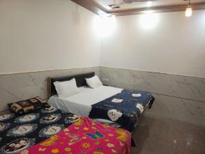 a small bedroom with two beds in a room at Maa chamunda dham in Mathura +9 photos