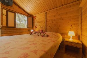 a bedroom with a bed in a log cabin at Camping Villaggio Egad in Favignana