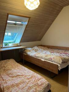 a attic bedroom with two beds and a window at Vestervang 1, 8654 Bryrup in Bryrup