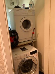 a washer and a washing machine in a small room at Laundry Cottage in Lanark