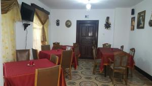 a dining room with two tables and chairs and a door at Dofteana Park in Leorzeni