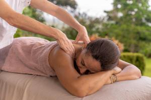 a woman is performing aorative massage on her back at Hotel Alto Monte Hacienda & Spa - Only Adults in Chiguirí Arriba